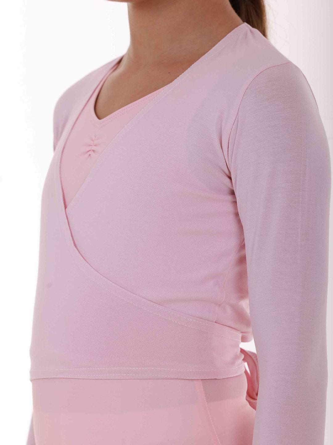 Cache-cœur rosa à mangas largas – zoom en le tissu doux y la couture croisée.