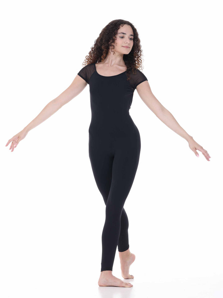 Danseuse portant la unitard Sway – modèle Sheer Cap Sleeve Dance Unitard en negro, adoptant une posture fluido avec les bras ouverts, sur fond blanco.