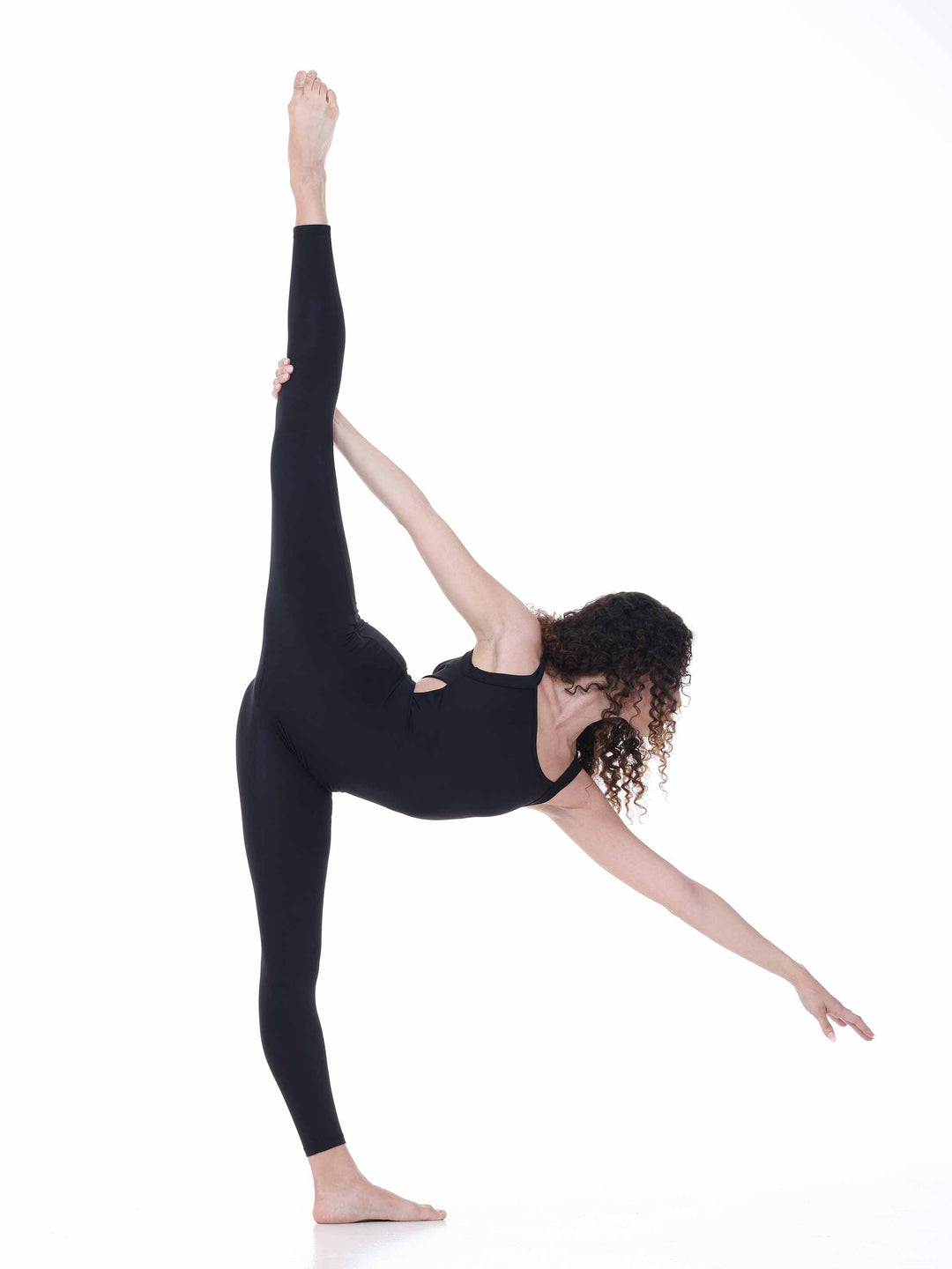 Danseuse en unitard negro effectuant une extension de jambe – tenue souple pour danza moderna ou yoga.