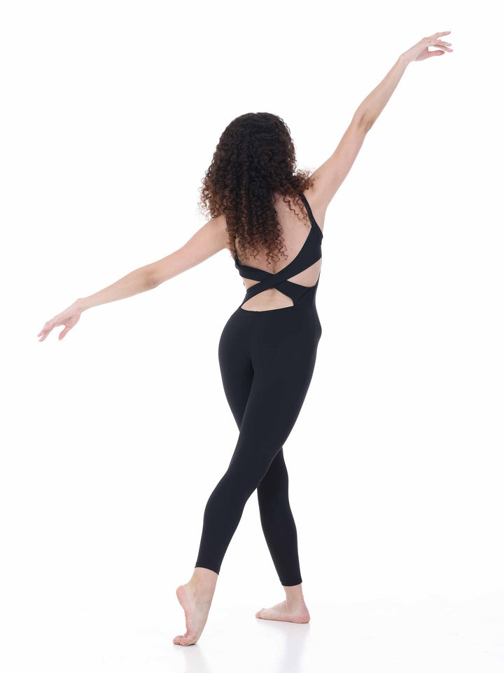 Danseuse en movimiento de ballet portant un unitard negro dos croisé – unitard elegante pour studio de danse.