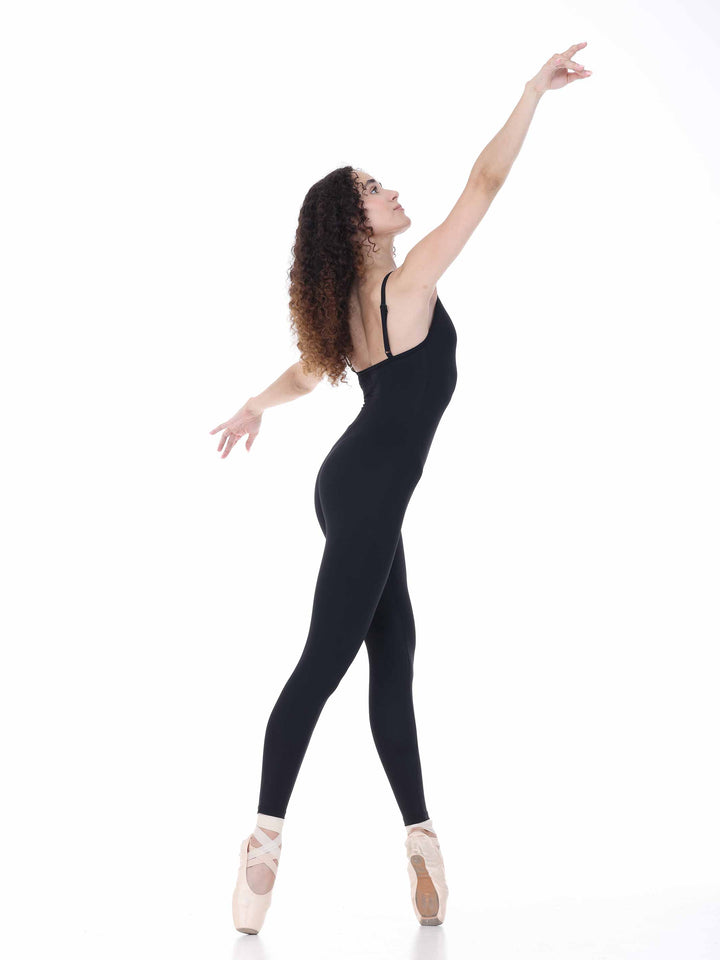 Profil de bailarina en unitard negro ajustado, pose élancée sur pointes – tenue elegante pour ballet.