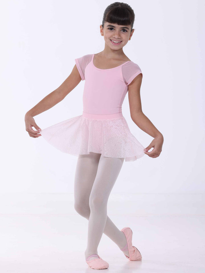 Jeune bailarina portant une falda de danse rosa clair – encaje florale y movimiento gracieux.