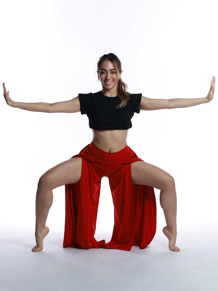 Danseuse en movimiento con pantalón de danse rojo – look expressif y ample.