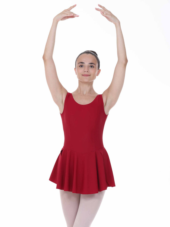 Danseuse en position de ballet avec une vestido de danse bordeaux – bretelles larges et falda évasée.